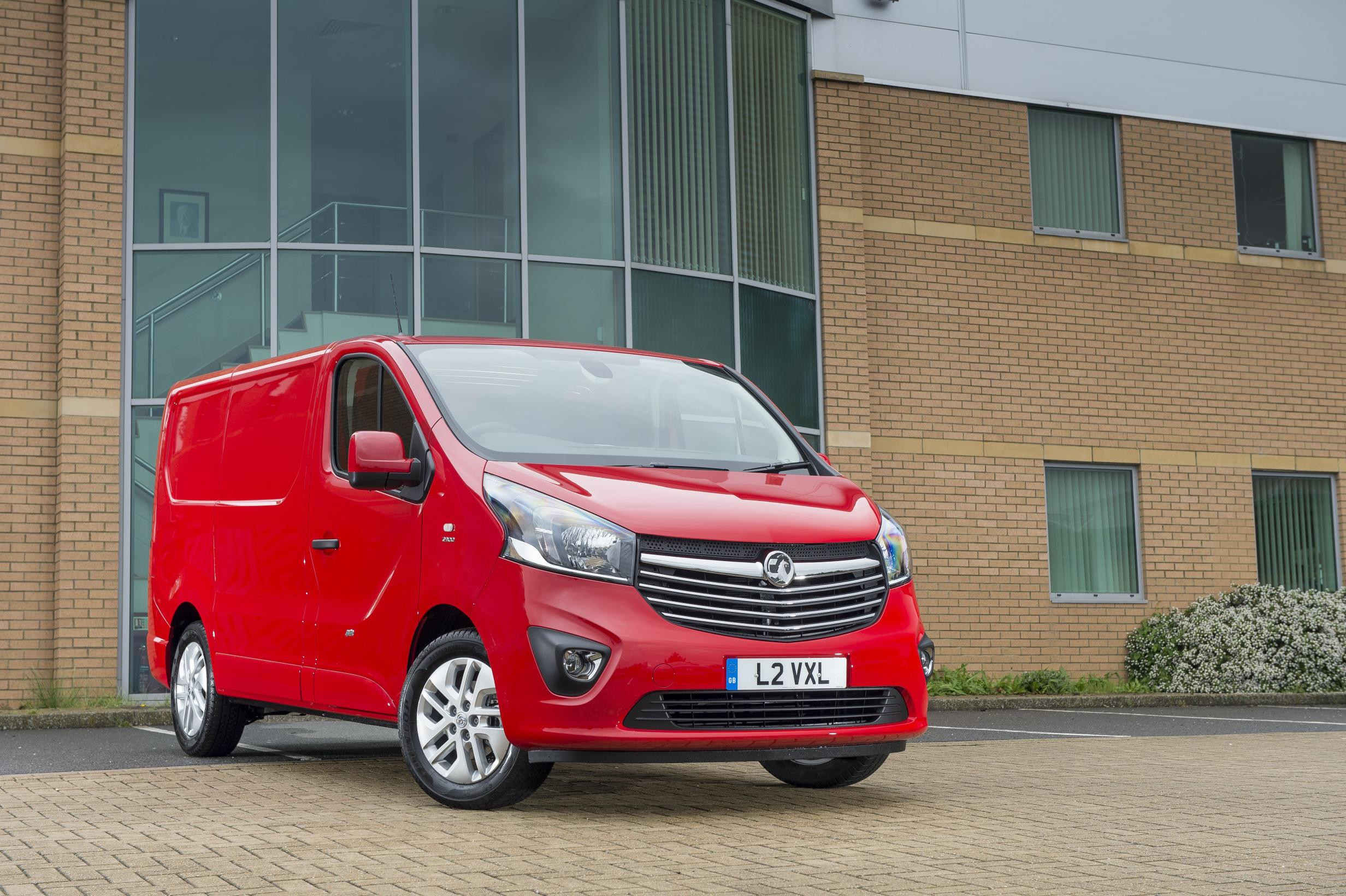 Red Vauxhall Vivaro parked in front of office unit, facing right